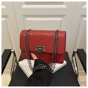 Detail of red faux leather handbag with weave texture and gunmetal chain strap