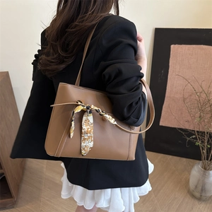 Brown soft leather tote bag with vintage scarf accent shown in a cozy interior setting