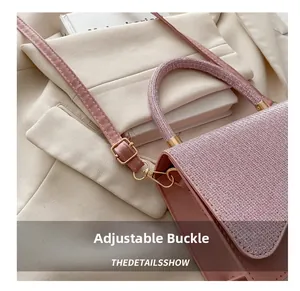 Detail of adjustable metal buckle on pink sequin bag strap with leather stitching