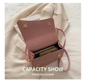 Practical capacity view of pink leather crossbody bag shown with a smartphone and wallet