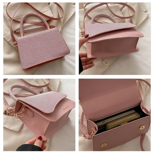 Macro detail of pink PU leather handbag showing texture, metal logo and interior space