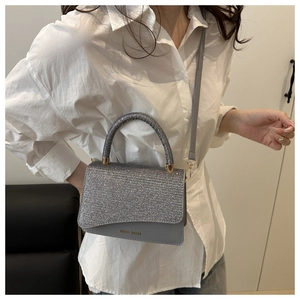 Detail showing glitter diamond flap and grey leather finish on mini crossbody bag