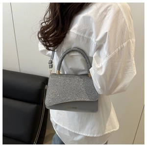Detail of grey rhinestone shoulder bag with silver sequins and golden hardware