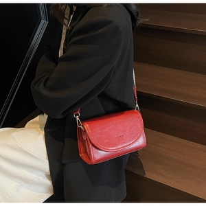 Burgundy faux leather crossbody bag with wide strap styled with a black blazer