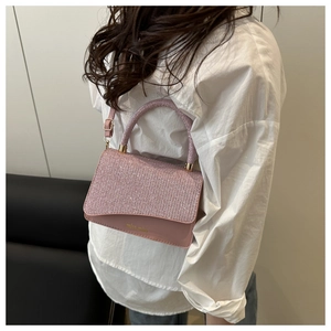 Close-up of pink sequined flap and gold logo on minimalist crossbody bag for women
