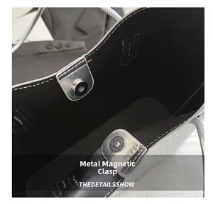 Detail view of the silver woven tote bag featuring secure double magnetic snap closures