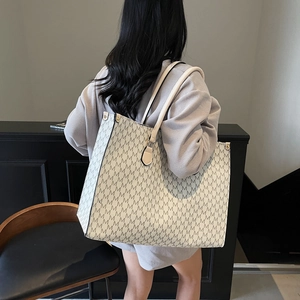 Chic tote bag with vintage M-pattern print and long handles for shoulder wear