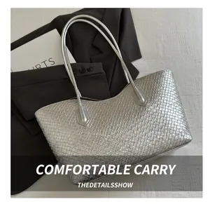 Close-up of silver woven tote bag texture with metallic finish and slim shoulder straps
