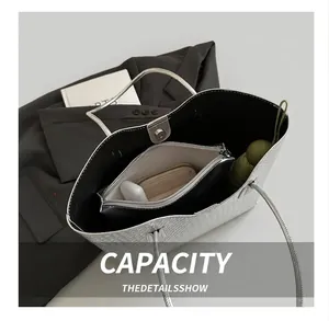 Spacious silver woven tote bag interior showing capacity with matching inner pouch and items