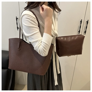Detail of dark brown woven tote bag set with matching small zipper pouch on casual background