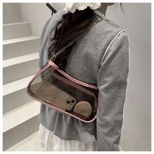 Détail du sac à bandoulière en PVC transparent avec bordure en cuir rose et chaîne dorée