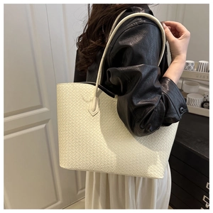 Close-up of white woven tote bag with diamond texture and elegant shoulder strap