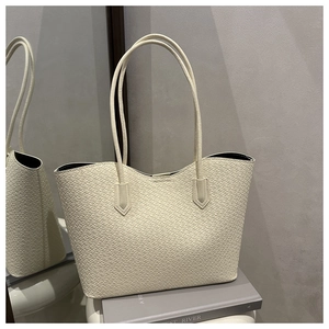 Detail of cream woven pattern tote bag showing high-capacity design and slim shoulder straps