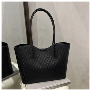 Detailed view of black woven faux leather texture on minimalist tote bag for women