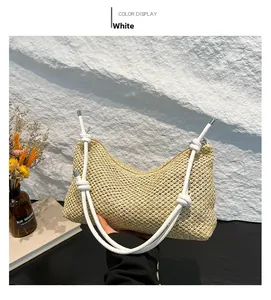 Close-up of the woven straw tote bag featuring decorative white rope handles and natural texture