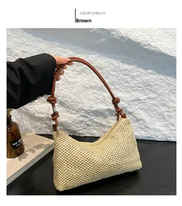 Detail of hand-woven straw tote bag with brown knotted leather strap on black blazer