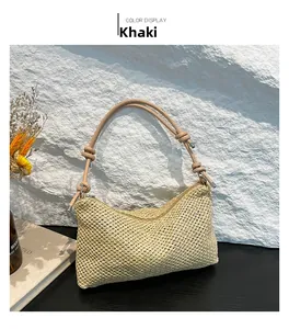 Detail view of khaki woven straw tote bag featuring smooth zipper and knotted straps