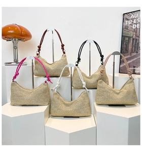 Detail of five moon-shaped straw tote bags with colorful knot handles on white stands