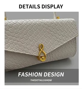 Close-up of white woven texture and elegant gold infinity metal clasp on the bag