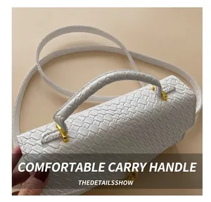 Detail of woven textured leather bag with gold hardware and comfortable handle