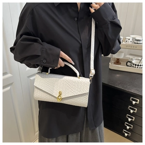 White faux crocodile leather baguette bag with a distinctive golden musical note clasp