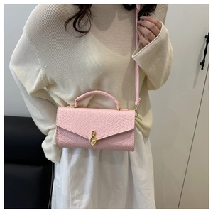 Detail view of pink woven texture crossbody bag with gold infinity clasp and long strap