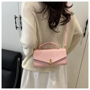 Detailed view of pink crocodile texture crossbody bag with gold metal buckle