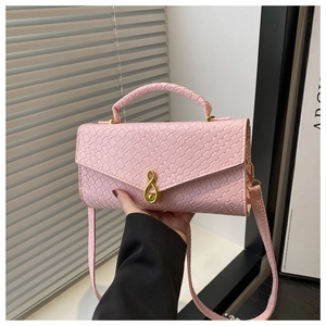 Detail of light pink hand bag featuring woven texture and gold musical note clasp