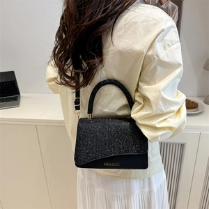 Minimalist black sequin crossbody bag with gold text and adjustable shoulder strap