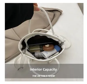Vista dall'alto della grande capacità interna della borsa in pelle bianca con accessori