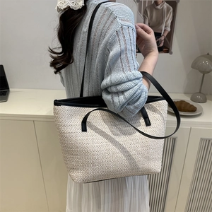 Chic woven tote bag with black leather straps and large capacity for summer fashion