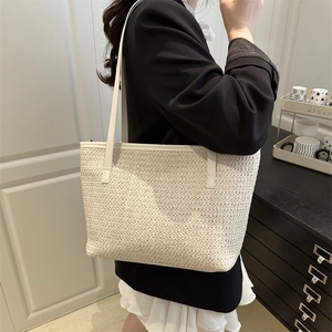 Chic cream woven straw tote bag with white leather handles for summer beach outings