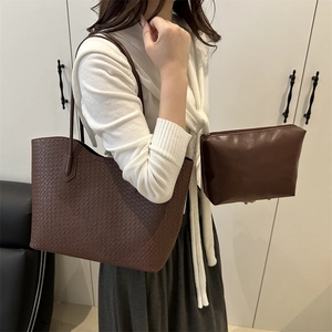 Deep brown woven tote bag set with matching inner pouch shown on a fashion model