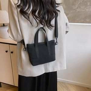Minimalist black small tote bag with adjustable shoulder strap for urban commute style