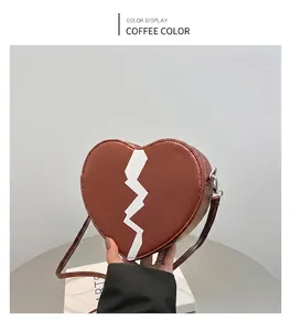 Detail view of heart-shaped brown PU leather crossbody bag with white jagged pattern