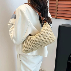 U-shaped woven shoulder bag with brown leather strap and knot detail for beach vacation