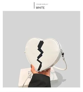 Detailed view of heart-shaped white PU leather bag with black lightning pattern and silver zip