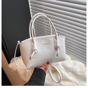 Détail d'un sac cabas blanc avec logo FASHION et poignées nouées élégantes
