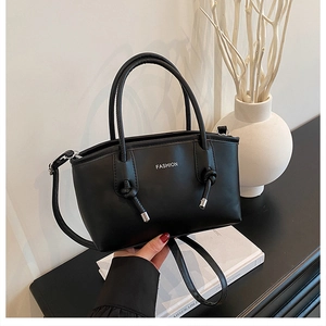 Détail du sac cabas en cuir noir avec imprimé FASHION et poignées à nœuds