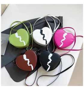 Top view of five heart-shaped crossbody bags in assorted colors with lightning stitch detail