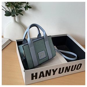 Detail of glitter green and blue mini tote bag showing texture and adjustable strap