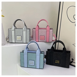 Close-up of sequin mini tote bags in silver, pink, blue, and black with 'THE BAG' patch