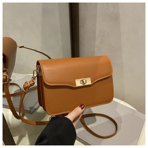 Detail of vintage brown rectangular handbag with a golden metal twist lock and matte leather