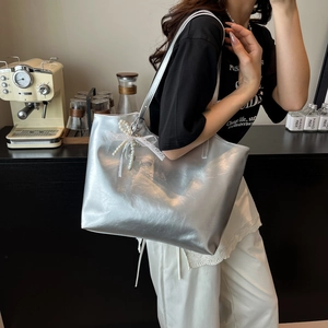 Metallic silver tote bag with white lace bow and pearl charm for casual commuting