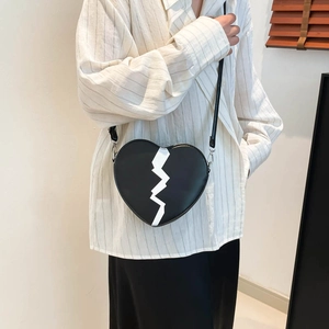 Fashionable heart-shaped crossbody bag with white lightning detail and leather strap