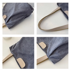 Macro detail of blue-gray corduroy tote bag showing textured fabric and fashion patch