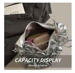 Internal view of silver pleated bag showing large storage capacity and purple lining detail