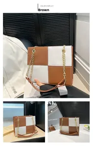 Detail view of the brown and white color-blocking square bag with gold chain strap