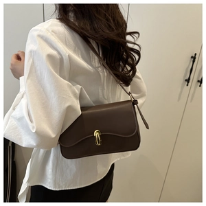Vue détaillée du petit sac bandoulière marron avec boucle cylindre dorée et lanière