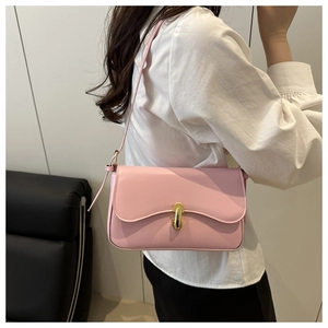 Detail of pink leather shoulder bag with wavy flap and golden buckle on model